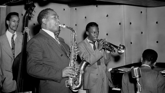 Die Jazz Combo "Three Deuces" bestehend aus Charlie Parker, Tommy Potter, Miles Davis, Duke Jordan und Max Roach bei einem Konzert auf der Bühne. Die Jazz Combo "Three Deuces" bestehend aus Charlie Parker, Tommy Potter, Miles Davis, Duke Jordan und Max Roach bei einem Konzert auf der Bühne. © IMAGO / Cinema Publishers Collection Foto: William P. Gottlieb