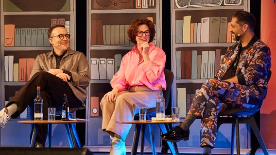 Daniel Schreiber, Ildikó von Kürthy und Gianni Jovanovic sitzen lachend auf einer Bühne. © Maren Janning Foto: Maren Janning