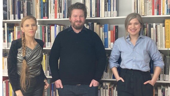 Lisz Hirn, Alexander Solloch und Nele Pollatschek stehen vor einer Bücherwand. © NDR Foto: Meike Egge