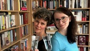 Lisa Kreißler und Juliane Bergmann stehen jeweils mit einem Glas Sekt beieinander. © NDR Foto: Birgit Bohle