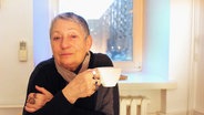 Ljudmila Ulitzkaja sitzt mit einer Tasse in der Hand an einem Tisch. © Claudia Thaler/dpa Foto: Claudia Thaler