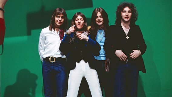 Die Band Smokie posiert 1977 vor der grünen Wand eines Fernsehstudios in der ARD Musiksendung "Scene 1977". © picture alliance/United Archives | kpa 