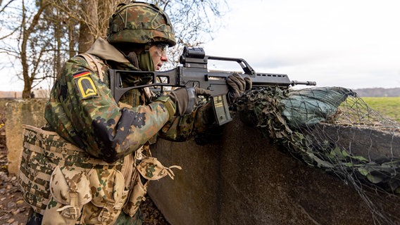 Ein Soldat steht im Schützengraben und zielt mit seinem Gewehr © picture alliance / Jens Koehler Foto: Jens Koehler