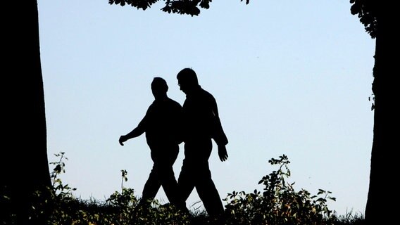 Zwei Männer gehen im Wald spazieren. © picture alliance / ASSOCIATED PRESS | Foto: Frank Augstein