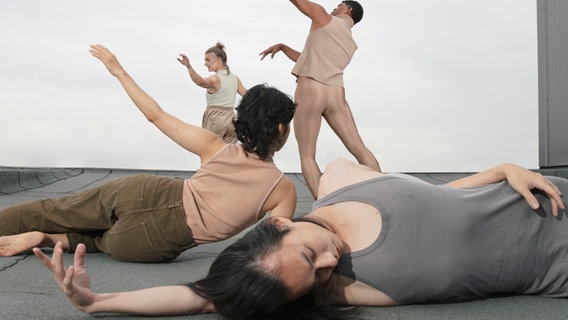 Tänzerinnen und Tänzer der Produktion "Swan Fate" bewegen sich auf der Bühne. © Friederike Höpnner 