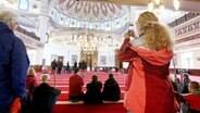 Besucher der DITIB-Moschee in Duisburg-Marxloh besichtigen den Gebetsraum während einer Führung. © picture alliance/dpa Foto: Roland Weihrauch