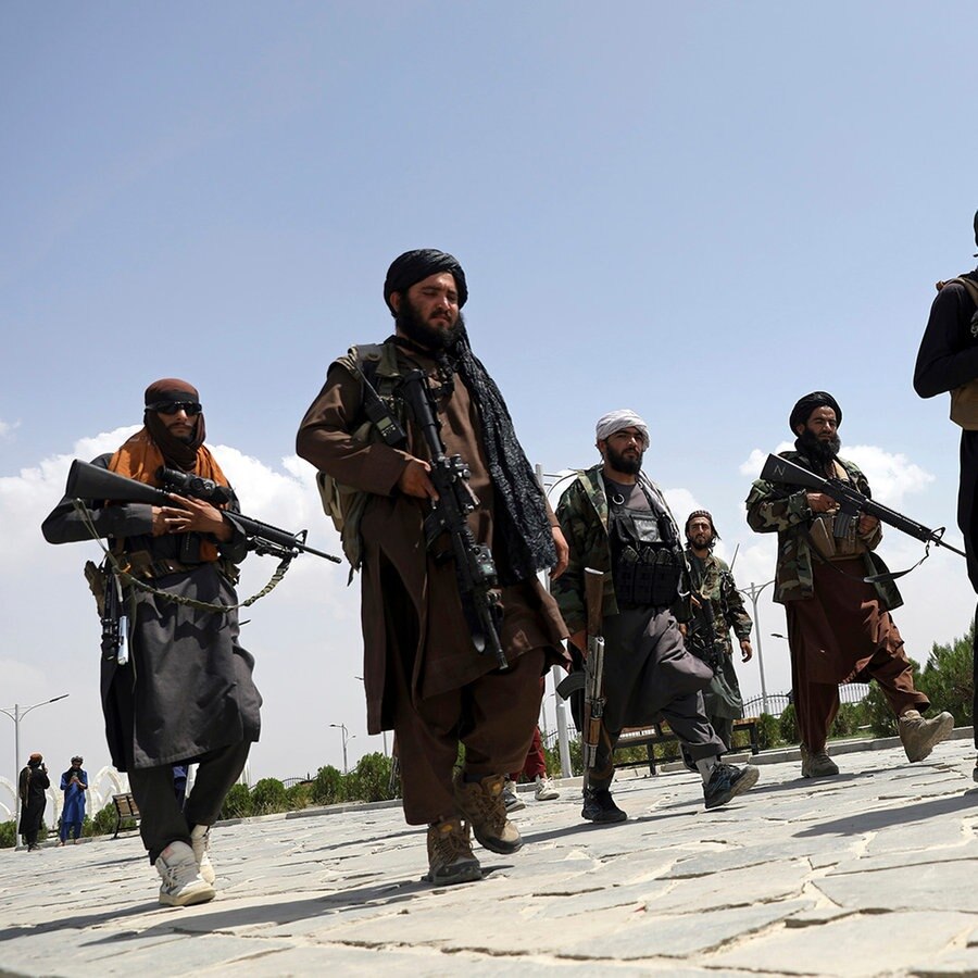 Schwer bewaffnete Taliban-Kämpfer patrouillieren nach ihrer Machtübernahme durch Kabul © picture alliance/dpa/AP Foto: Rahmat Gul