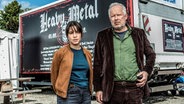 Schauspieler Axel Milberg mit Almila Bagriacik vor einem Truck - Szene aus "Tatort - Borowski und das unschuldige Kind von Wacken" ©  NDR/Thorsten Jander 