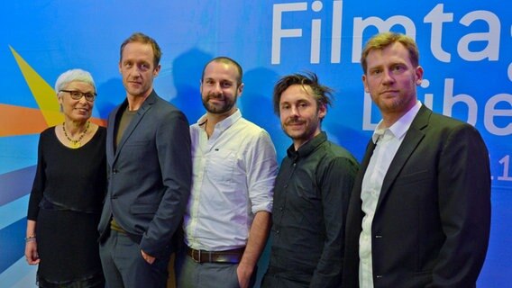 Linde Fröhlich (l.) und Florian Vollmers (r.), Leiter der Nordischen Filmtage Lübeck mit dem Filmteam von "Tian - Das Geheimnis der Schmuckstraße": Hauptdarsteller Stephan Kampwirth (v.l. ), Autor und Produzent Stefan Gieren und Regisseur Damian Schipporeit © NDR Foto: Patricia Batlle