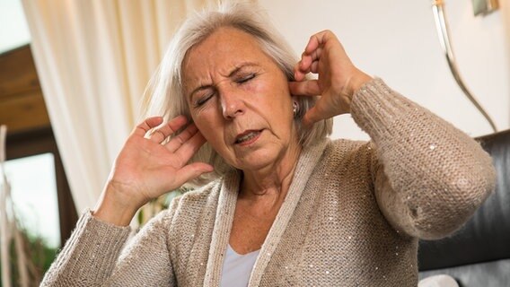 Eine Frau hält sich die Ohren zu © picture alliance / dpa-tmn Foto: Christin Klose
