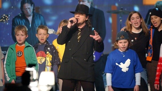 Udo Lindenberg und ein Kinderchor singen 2003 bei der ZDF-Spendengala "Ein Abend für den Frieden". © picture-alliance / dpa | Jens Kalaene 