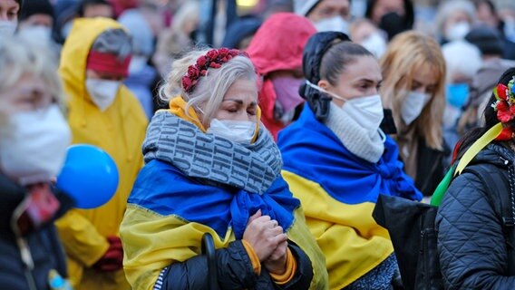 Frauen mit Ukrainefahnen um ihren Körper demonstrieren in Bremen gegen den Krieg in der Ukraine © Markus Hibbeler/dpa +++ dpa-Bildfunk +++ Foto: Markus Hibbeler