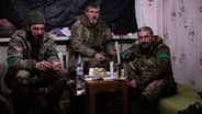 Drei ukrainische Soldaten in einer kleinen Hütte. © Agentur Focus/Sebastian Backhaus 