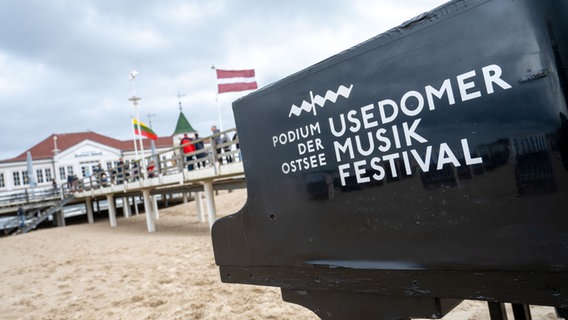 Ein Klavier-Flügel mit dem Logo des Usedomer Musikfestivals steht vor der Seebrücke Ahlbeck am Strand der Insel Usedom. © picture alliance/dpa | Stefan Sauer Foto: Stefan Sauer