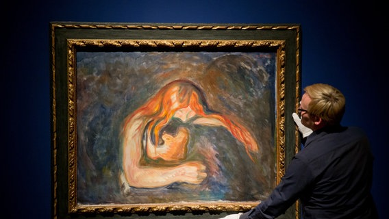 Ein braun-gelb gehaltenes, sehr dunkles Bild, das schemenhaft zwei in sich verschlungene Menschen zeigt. Es ist das Bild "Vampire" von Edvard Munch. © picture-alliance/ dpa | Norbert_Foersterling Foto: Norbert Foersterling