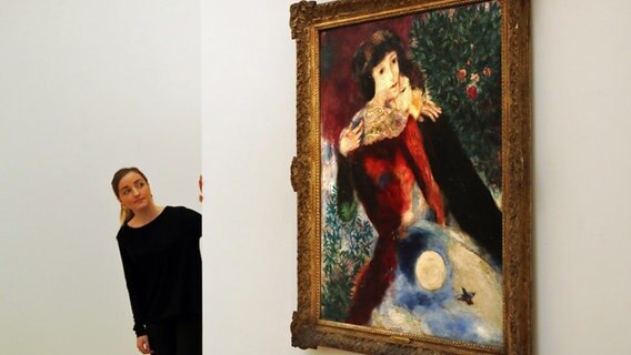 Eine Frau schaut sich das Chagall-Gemälde "Les Amoureux" im Auktionshaus Sotheby's an. © picture alliance / AP Photo Foto: Frank Augstein