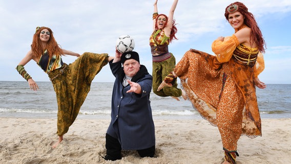 Drei Schauspielerinnen und ein Schauspieler in Kostümen proben am Strand von Zinnowitz eine Szene für das Stück "Vineta - Das Elfenspiel". © dpa 