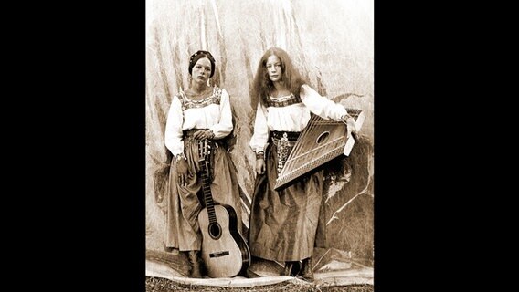 Zwei Frauen mit Gitarre und Hackbrett auf einer Schwarz-Weiß-Fotografie. © FlareFilm 