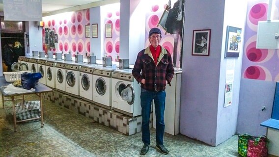 Ausstellungsmacher und Künstler Rasmus Gerlach vor den Waschmaschinen. © NDR Foto: Peter Helling