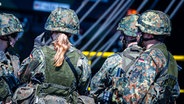 Eine Soldatin und drei Soldaten in der Rückenansicht. © picture alliance/dpa | Jens Büttner 