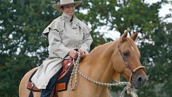 Western-Reittrainerin Petra Lösche sitzt auf einem Pferd. © Petra Lösche 