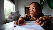Der vietnamesische Junge Long Thanh schreibt Tagebuch. © NDR Foto: Philipp Abresch
