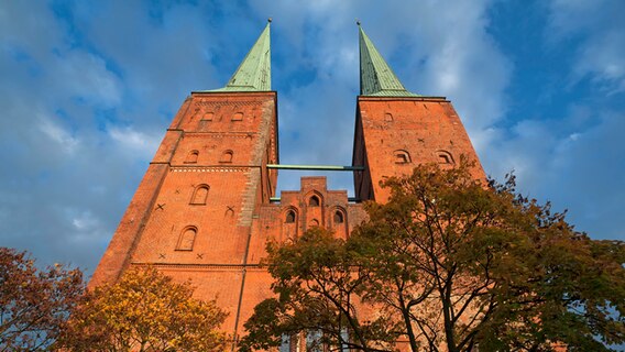 Westtürme im Abendlicht vom Lübecker Dom, roter Backsteinkirchbau, 1247 geweiht, 1266 bis 1335 zu einer gotischen Hallenkirche umgebaut, Lübeck, Schleswig-Holstein © picture alliance / imageBROKER | Helmut Meyer zur Capellen Foto: Helmut Meyer zur Capellen