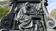 Das Lutherdenkmal auf dem Karlsplatz in Eisenach aus dem Jahr 1895 zeigt Luther während der Bibelübersetzung. © picture alliance/dpa/dpa-Zentralbild Foto: Martin Schutt