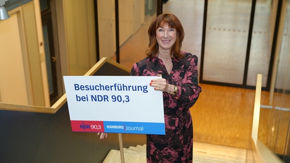 Moderatorin Maren Bockholdt hält ein Schild für die Besucherführungen bei NDR 90,3 hoch. © NDR Foto: Marco Peter