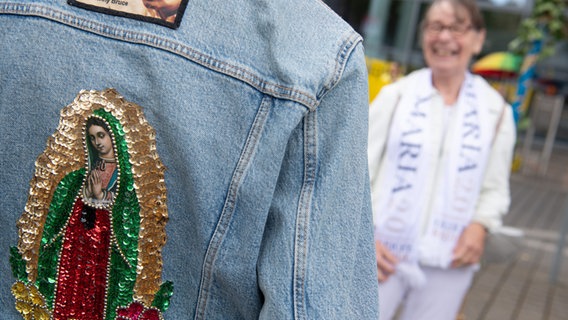 Eine Frau trägt ein Marienbild auf ihrer Jeansjacke. © picture alliance/dpa | Sebastian Gollnow Foto: Sebastian Gollnow