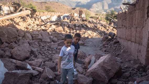 Rayan und Ali gehen durch die Trümmer ihres Hauses in Marrakesch, das durch das Erdbeben beschädigt wurde. © AP/dpa Foto:  Mosa'ab Elshamy