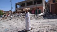 Marrakesch: Ein Mann geht entlang der Trümmer von Gebäuden nach einem Erdbeben. © AP/dpa Foto: Mosa'ab Elshamy