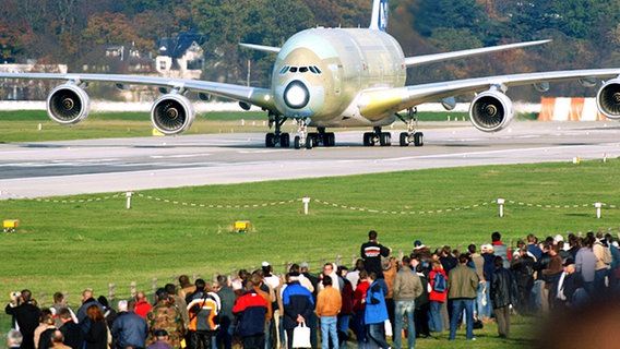 Ein Airbus A380 rollt auf dem Werksflugplatz in Hamburg-Finkenwerder an zahlreichen Zuschauern vorbei. © dpa - Report Foto: Maurizio Gambarini