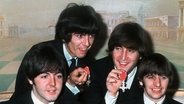 Paul McCartney, George Harrison, John Lennon und Ringo Starr mit den Orden "Member of the Order of the British Empire" (Aufnahme vom 26. Oktober 1965) © dpa 