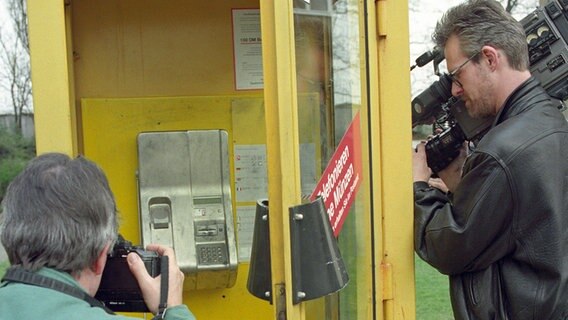 Kameramann und Fotograf vor der Berliner Telefonzelle, in der Kaufhauserpresser Dagobert am 22. April 1994 festgenommen wurde. © dpa Foto: Bernd Settnik