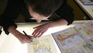 Ein Mitarbeiter des Braunschweiger Westermann-Verlags zeichnet eine Karte für den kommenden Diercke-Weltatlas © dpa-Bildfunk Foto: Jochen Lübke