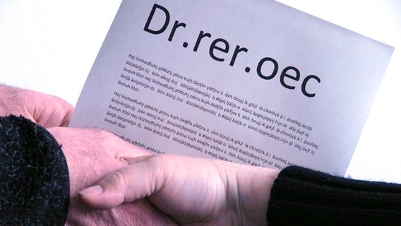 Ein Blatt Papier mit dem Titel: "Dr.rer.oec" wird übergeben © NDR Foto: Harald Ganswindt