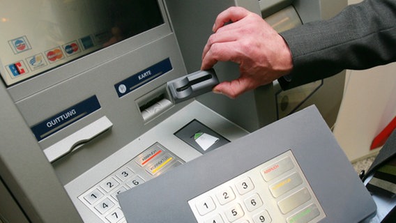 Ein Mitarbeiter der Sparkasse demonstriert an einem Geldautomaten die "Skimming"-Technik. © dpa Foto: Thomas Frey