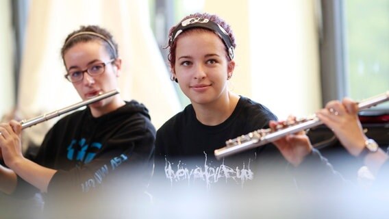 Ein Mädchen sitzt zwischen zwei Flötenspielerinnen © BR Foto: Astrid Ackermann