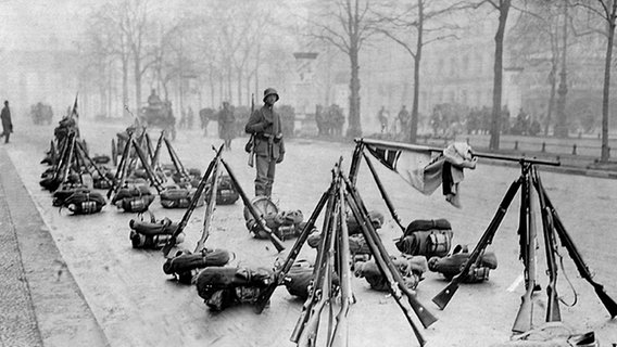 Blick auf die Berliner Allee Unter den Linden um sieben Uhr morgens am 13. März 1920: Koppel liegen aufgereiht, Gewehre sind aneinandergelehnt, die Flagge der Reichsmarine weht. © dpa 