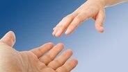 Eine Hand greift helfend nach einer fremden Hand. © Fotolia.com Foto: ZTS