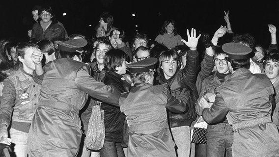 Begeisterte Jugendliche, die keinen Einlass zu dem Friedenskonzert des westdeutschen Musikers Udo Lindenberg gefunden haben, versuchen am 25. Oktober 1983 vor dem Palast der Republik in Ostberlin die Absperrung durch die Volkspolizei zu durchbrechen. © picture-alliance / dpa Foto: Klar