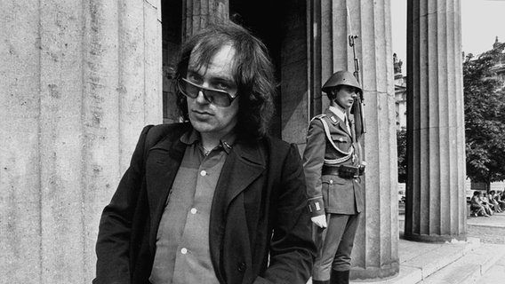 Udo Lindenberg posiert 1977 in Ost-Berlin vor der Neuen Wache, im Hintergrund ein Wachposten. © picture alliance / dpa | Dieter Klar 