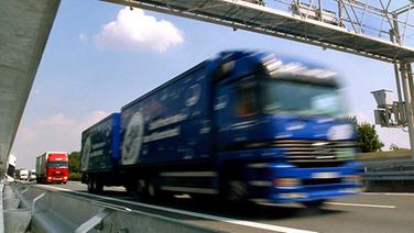 Ein Lastwagen fährt auf einer Autobahn unter einer Maut-Kontrollbrücke durch. © dpa Foto: Rolf Vennenbernd