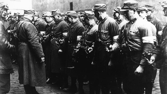 Männer der SA bekommen 1933 Waffen überreicht. © picture-alliance / AKG 