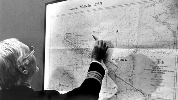 Ein Mitglieder der Reederei Hapag-Lloyd erläutert an Hand einer Karte die Suche nach dem Frachter "München". © picture-alliance / dpa Foto: DB