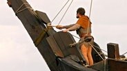 Ein Mann steht am Bug eines Schiffes und hält Ausschau. © NDR/ECO Media 