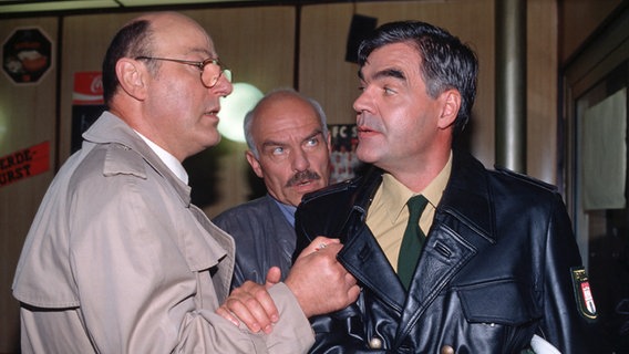 Am liebsten möchte Kommissar Stoever (Manfred Krug, links) auf den unzuverlässigen Klaus Schuster (Michael Greiling, rechts) los gehen: warum lügt der Kollege des Toten so offensichtlich? Brockmöller (Charles Brauer, Mitte) kann Stoever nur mit Mühe zurück halten. © © NDR 
