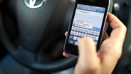 Mann schreibt SMS am Steuer. © Picture Alliance 