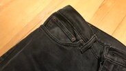 Eine Jeanshose liegt auf einem Tisch. © NDR/N-JOY 